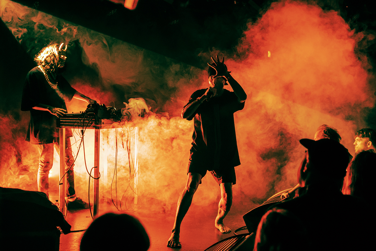The two members of DIEMAJIN on stage at Le Guess Who?, bathed in orange lights and smoke.